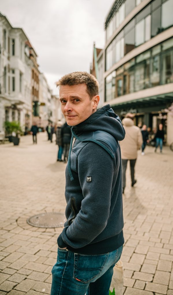 Finanzcoach Robert Mayer in Fußgängerzone laufend.